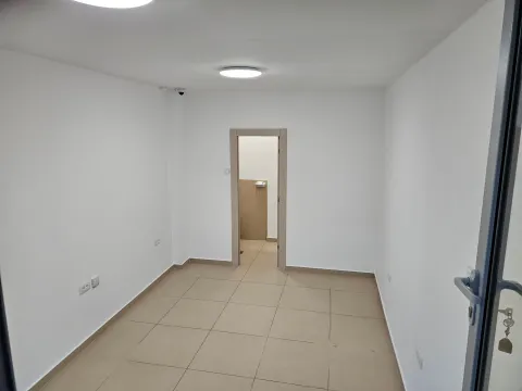 An empty bright room with tiled flooring and a doorway leading to another room. - image 3