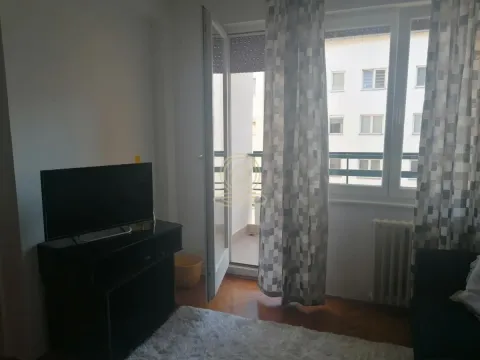 Dnevna soba sa televizorom, trosedom i izlazom na terasu. - image 3