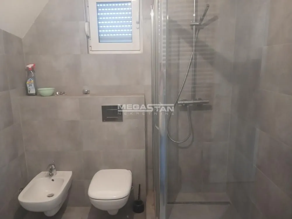 Moderno kupatilo sa tuš kabinom, WC šoljom i bideom.