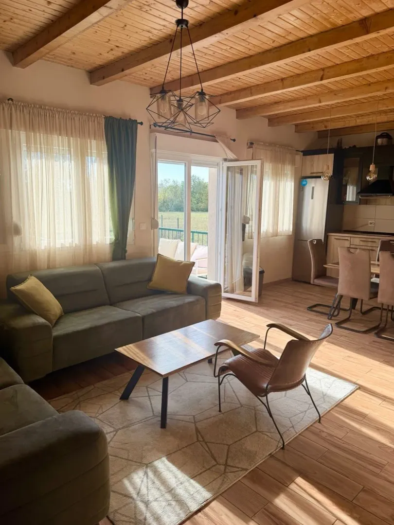 Spacious living room with a wooden ceiling connected to the dining area and kitchen.