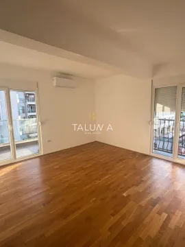 Empty room with hardwood floors and double balcony doors. - image 2