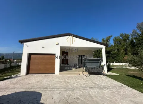 Front view of a single-story house with a garage and paved yard. - image 13