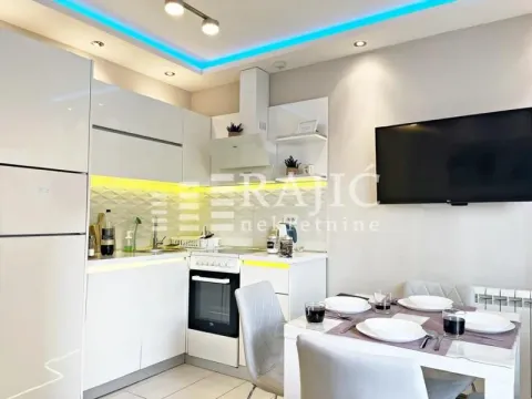 Modern kitchen with dining area and built-in appliances. - image 9