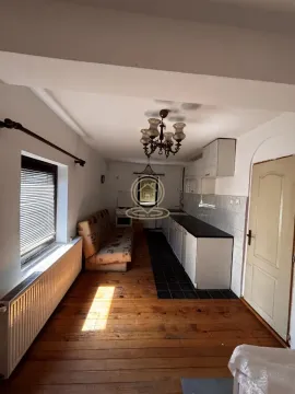 Long kitchen with wooden floor, sofa and white cabinets. - image 5