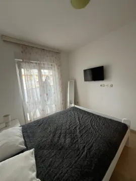 Svijetla spavaća soba sa bračnim krevetom i televizorom. - image 4