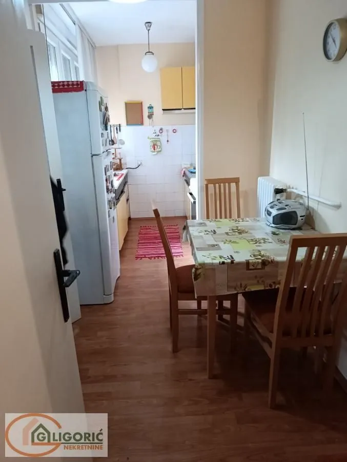 Manja kuhinja sa trpezarijskim stolom i stolicama.