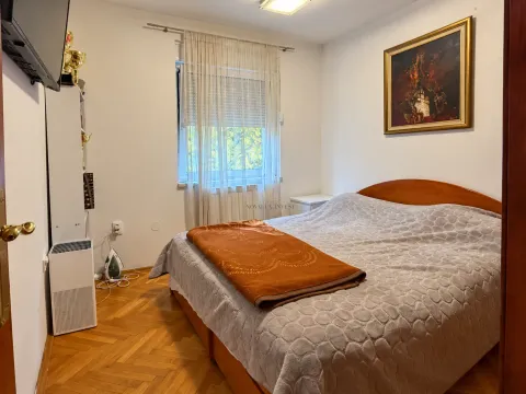 Spavaća soba sa bračnim krevetom, drvenim parketom i prozorom sa zavjesama. - image 6