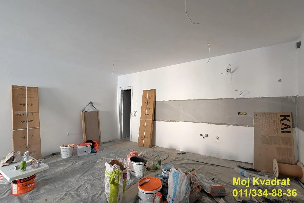 Prazna prostorija u toku renoviranja sa građevinskim materijalom.