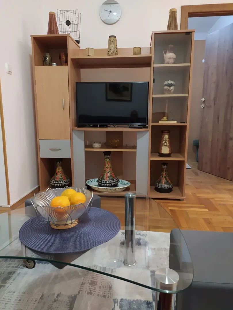 Living room featuring a wooden TV unit and a glass coffee table in the foreground.