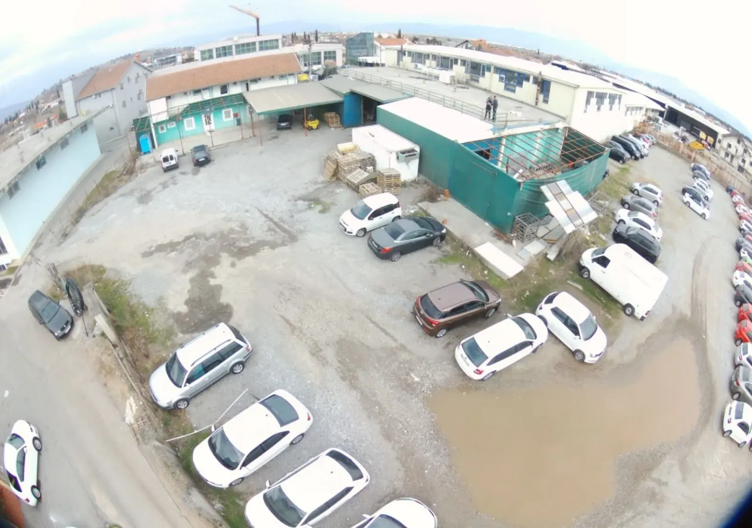 Aerial view of a spacious parking lot and commercial buildings.