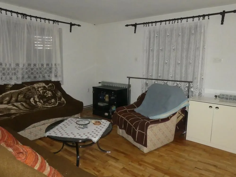 Living room with seating furniture, coffee table, and windows.