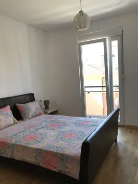 Bright bedroom with a double bed and balcony access. - image 7