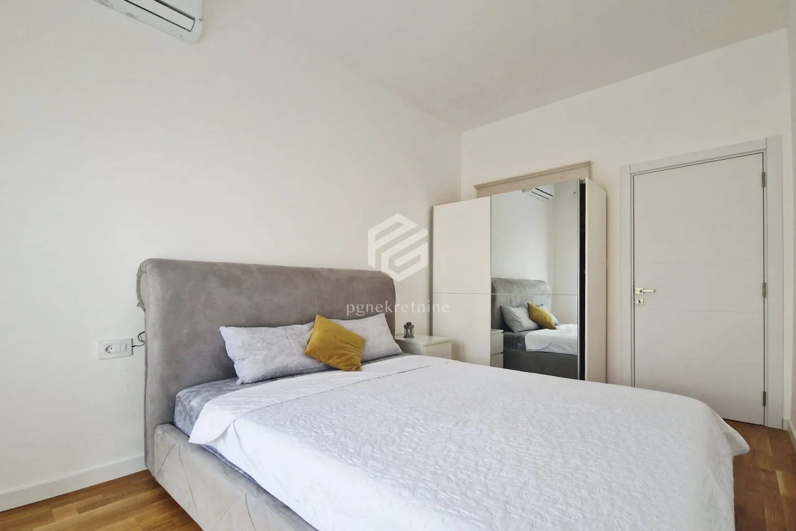 Furnished bedroom with a double bed, wardrobe, and white doors.