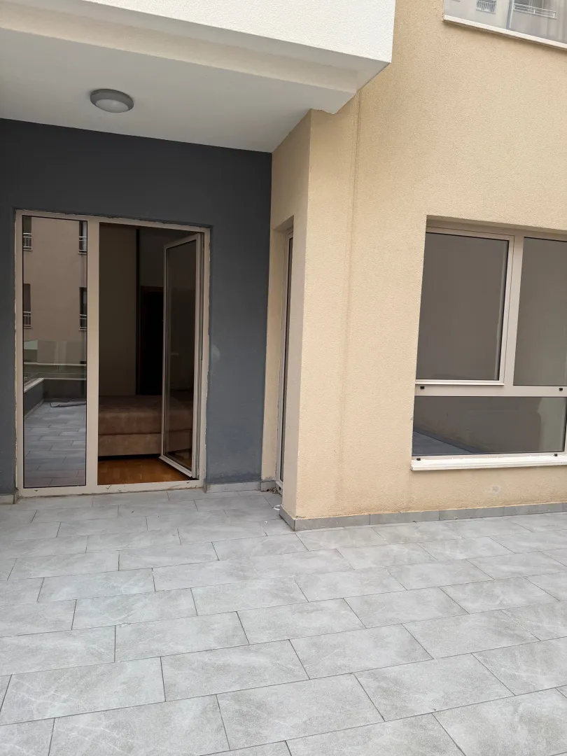 Terrace with tiled flooring and apartment entrance.