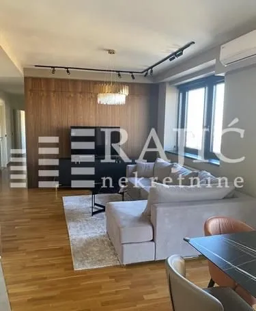 Spacious living room with a sofa and wood wall paneling.