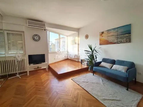 Dnevna soba sa garniturom, parketom i izdignutim delom sa prozorima. - image 4