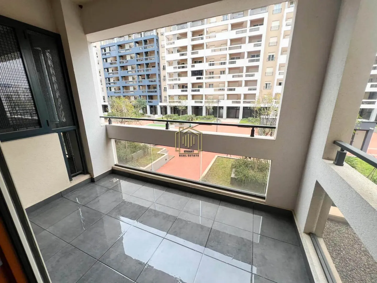 Covered terrace with a view of neighboring buildings and courtyard.