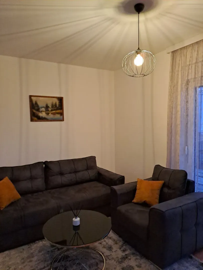 A living room featuring dark seating and a round coffee table.