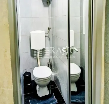 Small bathroom with a toilet and wall tiles. - image 8