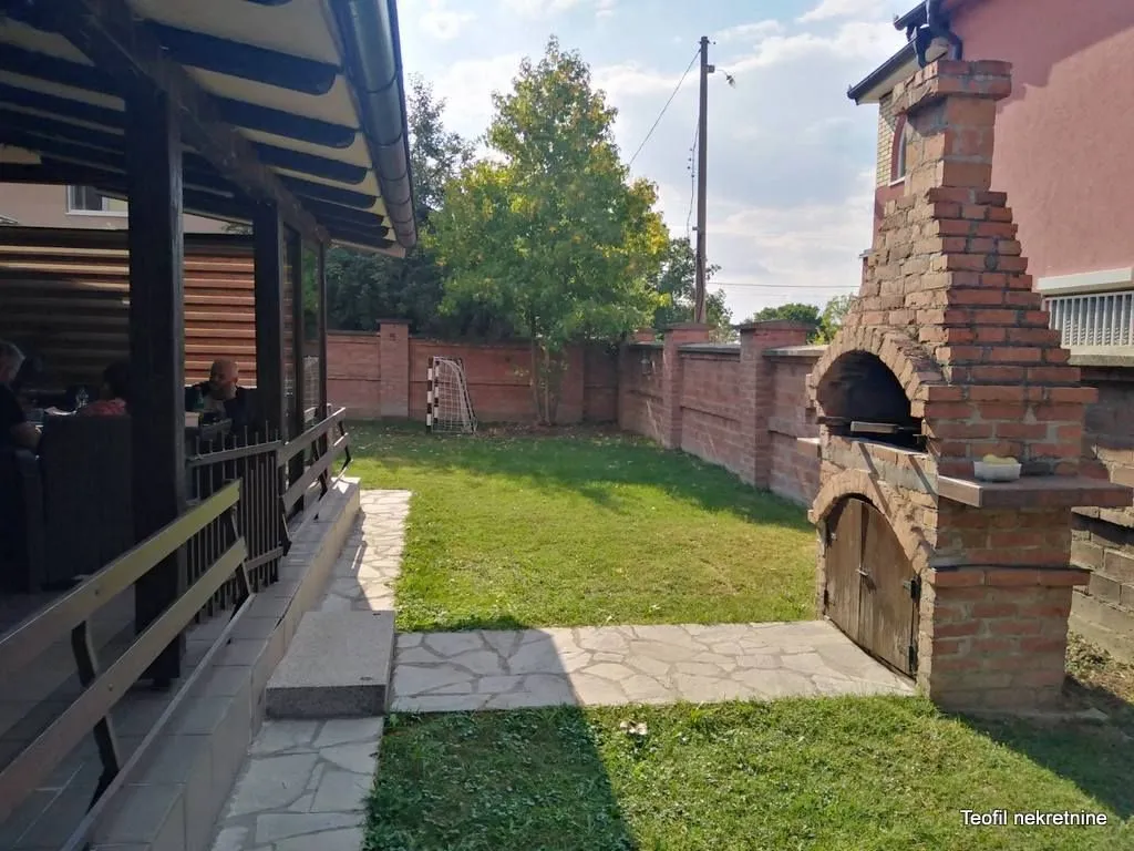 Dvorište sa natkrivenom terasom i zidanim roštiljem.