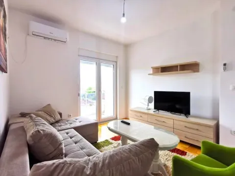 Svijetao dnevni boravak sa ugaonom garniturom, televizorom i izlazom na terasu. - image 2