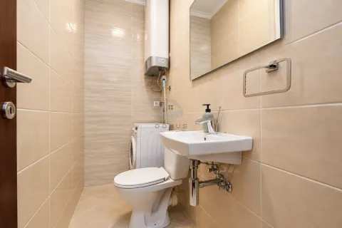 Kompaktno kupatilo obloženo bež pločicama sa umivaonikom, WC šoljom i veš mašinom. - image 22