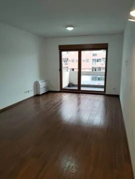 Prazna soba sa tamnim parketom i izlazom na terasu. - image 2