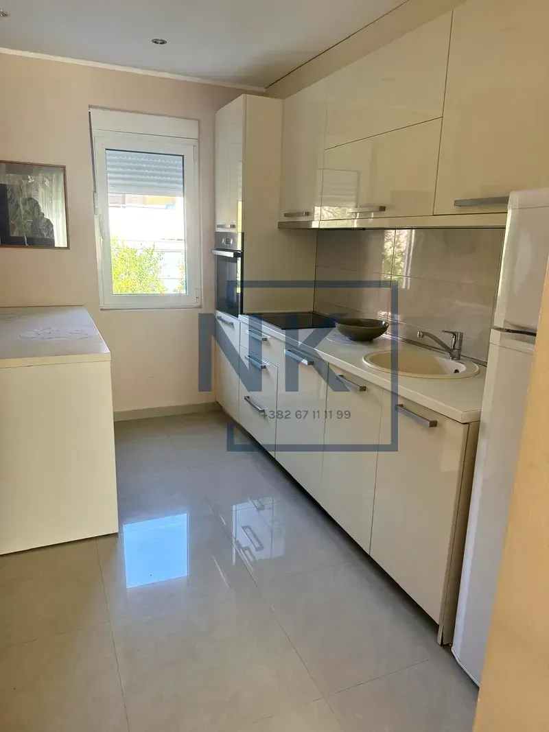 Smaller kitchen with light-colored cabinets and a window.