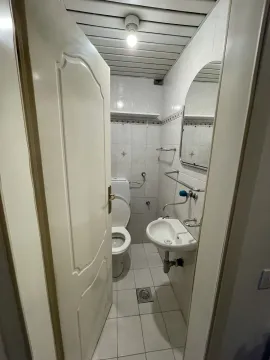 A simple bathroom with a toilet and a sink. - image 7