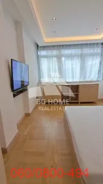 Bedroom with a bed, wall-mounted TV, and a chest of drawers under the window. - image 11