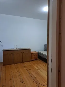 View from the hallway into a bedroom with wooden flooring and furniture. - image 7