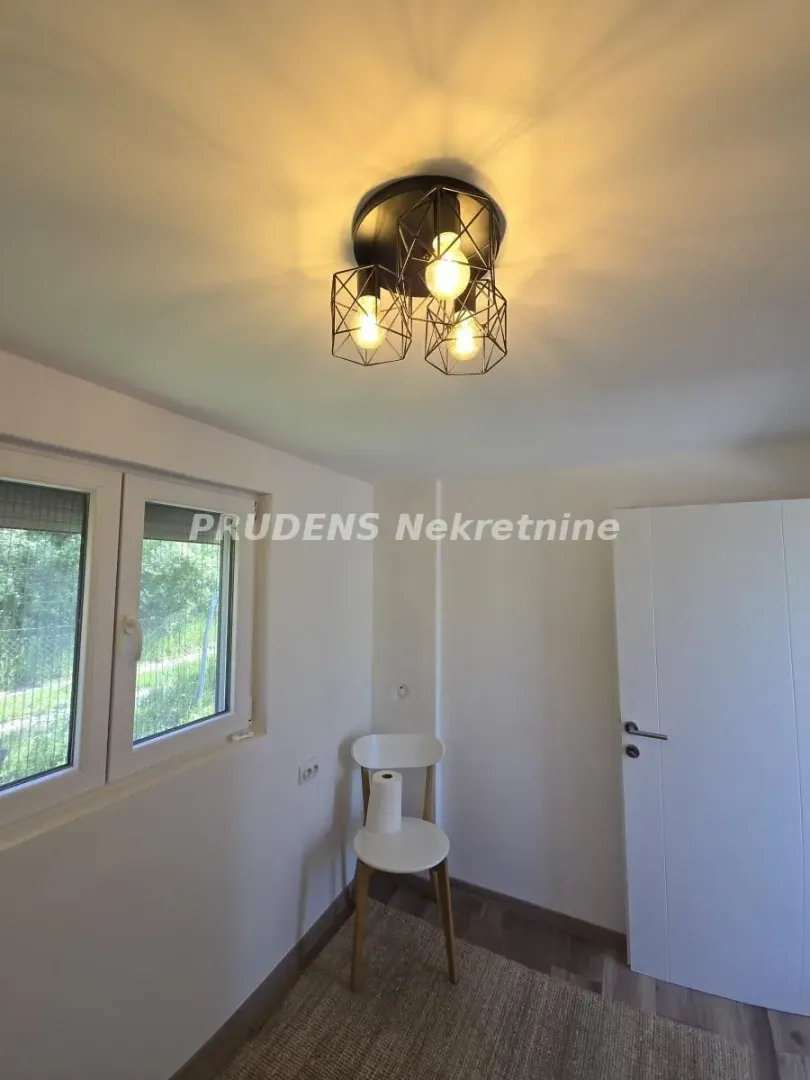Small room with a window, a white door, and modern ceiling lighting.