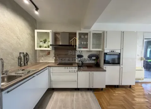Moderna kuhinja sa bijelim elementima i drvenim radnim površinama. - image 16