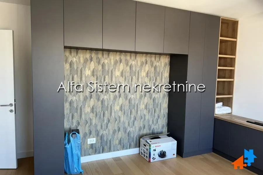 Bedroom with built-in wardrobes and decorative wallpaper on the wall.