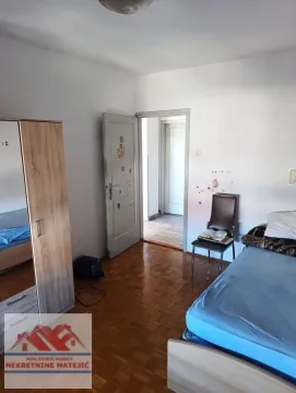 Furnished bedroom with a bed, wooden wardrobe, and parquet flooring. - image 11
