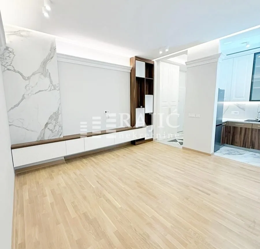 Modern living room with wooden flooring and built-in furniture.