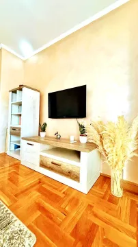 Living room with a television, wooden TV unit and bookshelf. - image 6