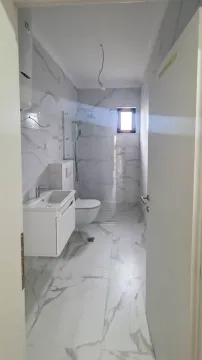 Pogled na moderno opremljeno kupatilo sa tuš kabinom i mermernim pločicama. - image 4