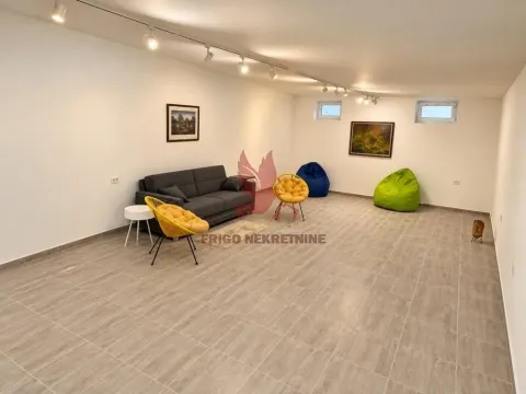 Prostrana dnevna soba sa garniturom za sedenje i slikama na zidu. - image 12