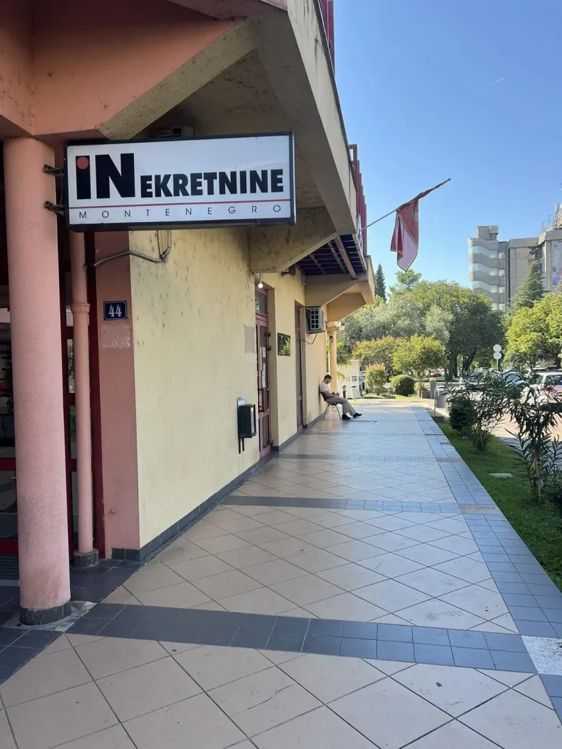 Entrance to a commercial space with a sign on the building facade.