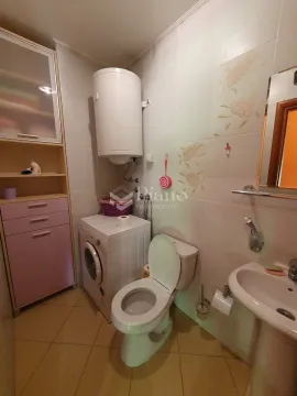 Bathroom equipped with sanitary fixtures, a washing machine, and a storage cabinet. - image 10