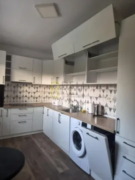 Modern white kitchen with a built-in washing machine. - image 3