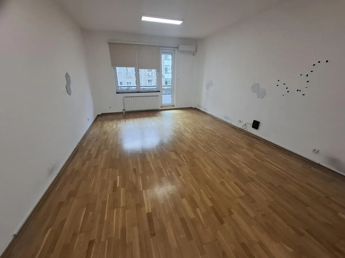Prazna soba sa drvenim podom i prozorom.