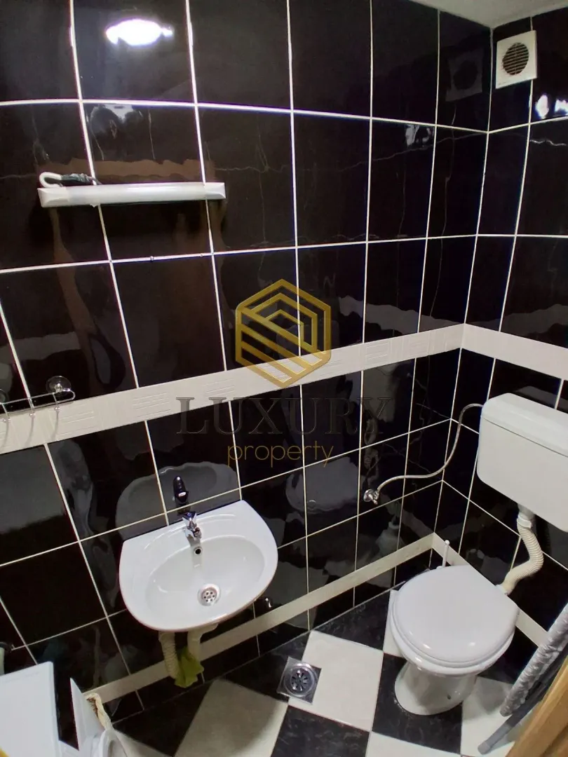 Smaller bathroom with black tiles and white sanitary ware.
