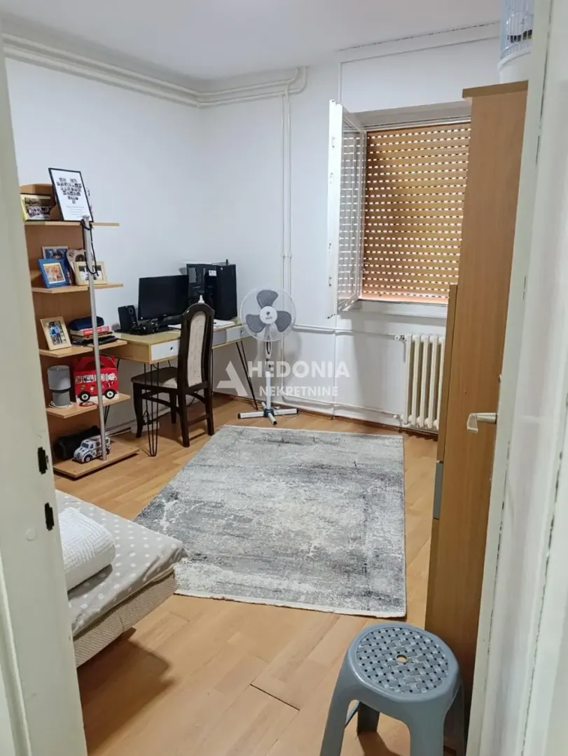 Dnevna soba sa radnim stolom i policama za knjige.