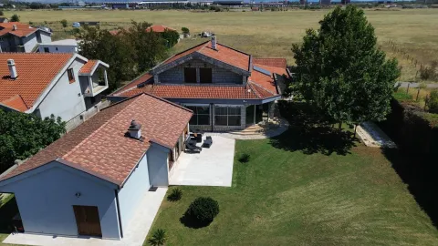 Pogled iz vazduha na kuću sa uređenim dvorištem i terasom. - image 2