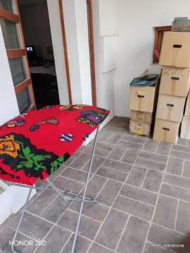 Natkrivena terasa sa daskom za peglanje i kutijama za selidbu. - image 9