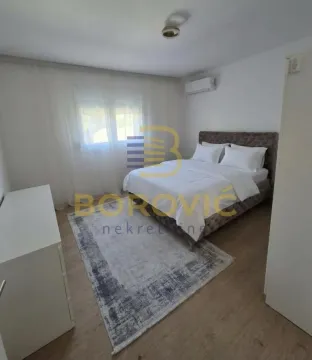 Bedroom with a double bed, rug, and air conditioning unit. - image 8