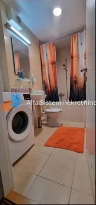Kupatilo opremljeno sanitarijama, tuš kabinom i veš mašinom.