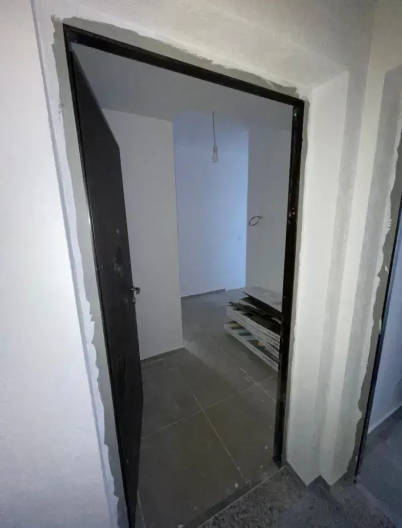 Pogled kroz otvorena vrata na nenamještenu prostoriju u toku adaptacije.